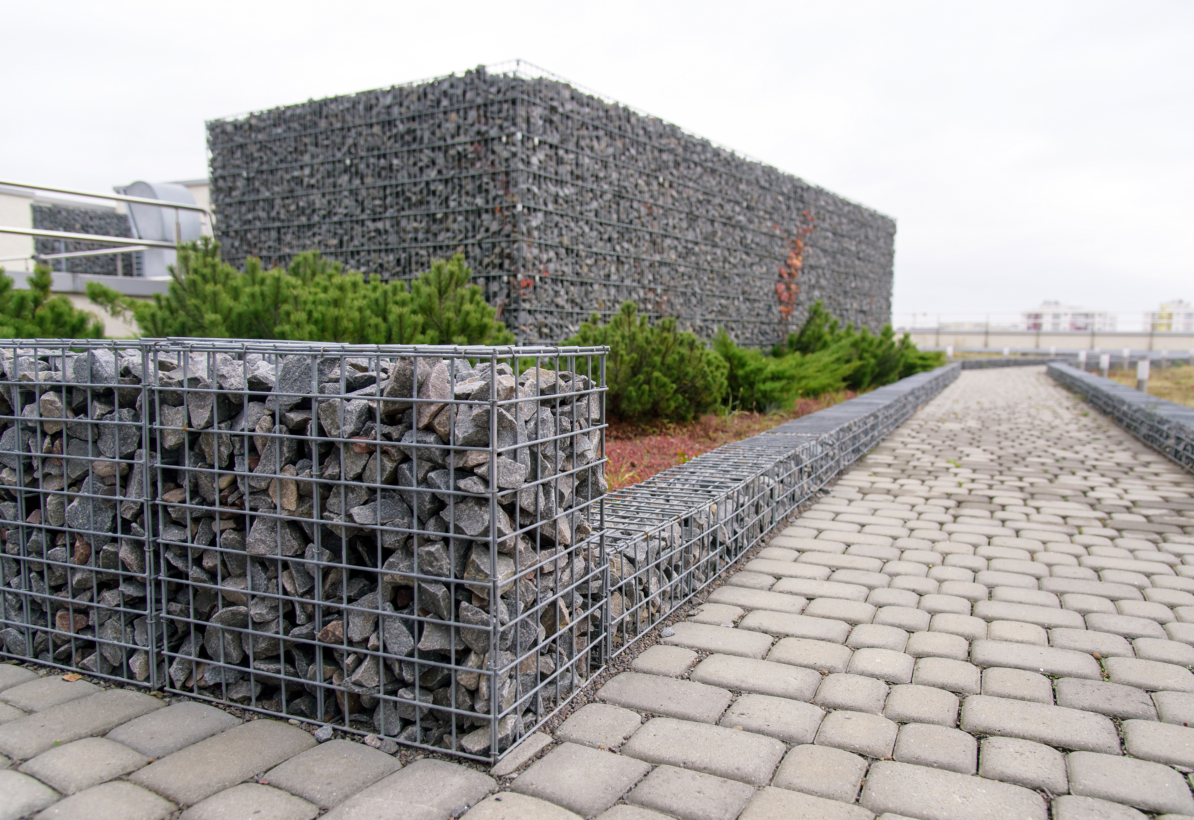 Gabion stone fence. Elements of angular rock and wire mesh gabions.